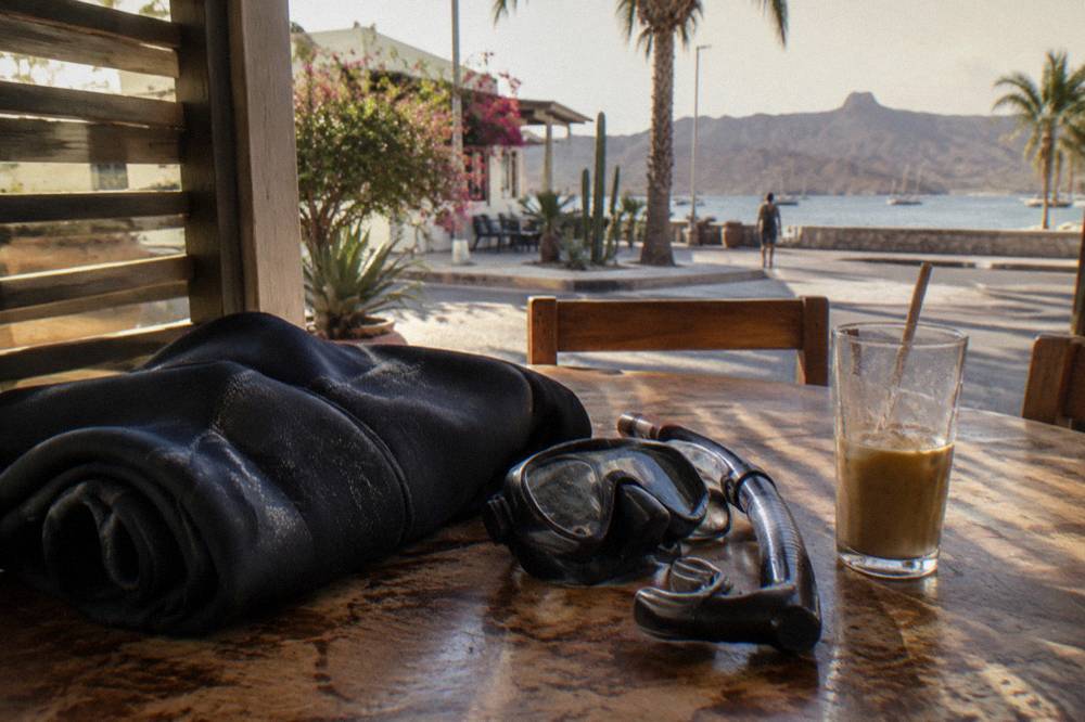 Snorkel gear and a wetsuit laid out on a boat bench before a whale shark swim