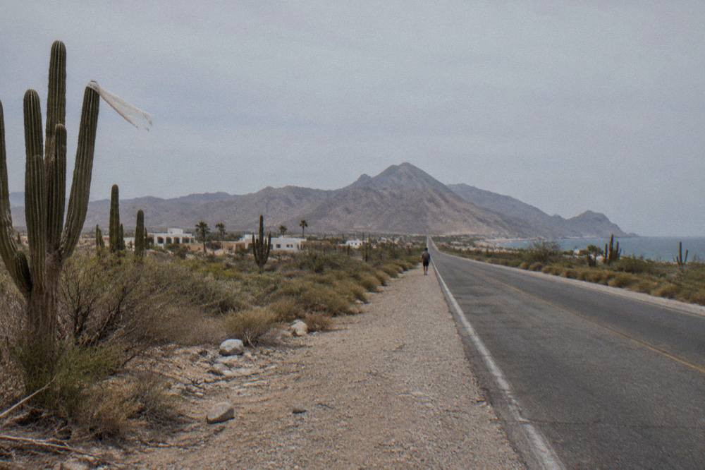 Desert highway stretching toward distant mountains under a wide sky on the Baja peninsula