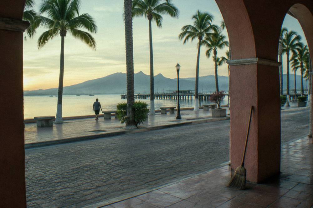 Quiet morning street along the La Paz waterfront with palm trees and calm bay water