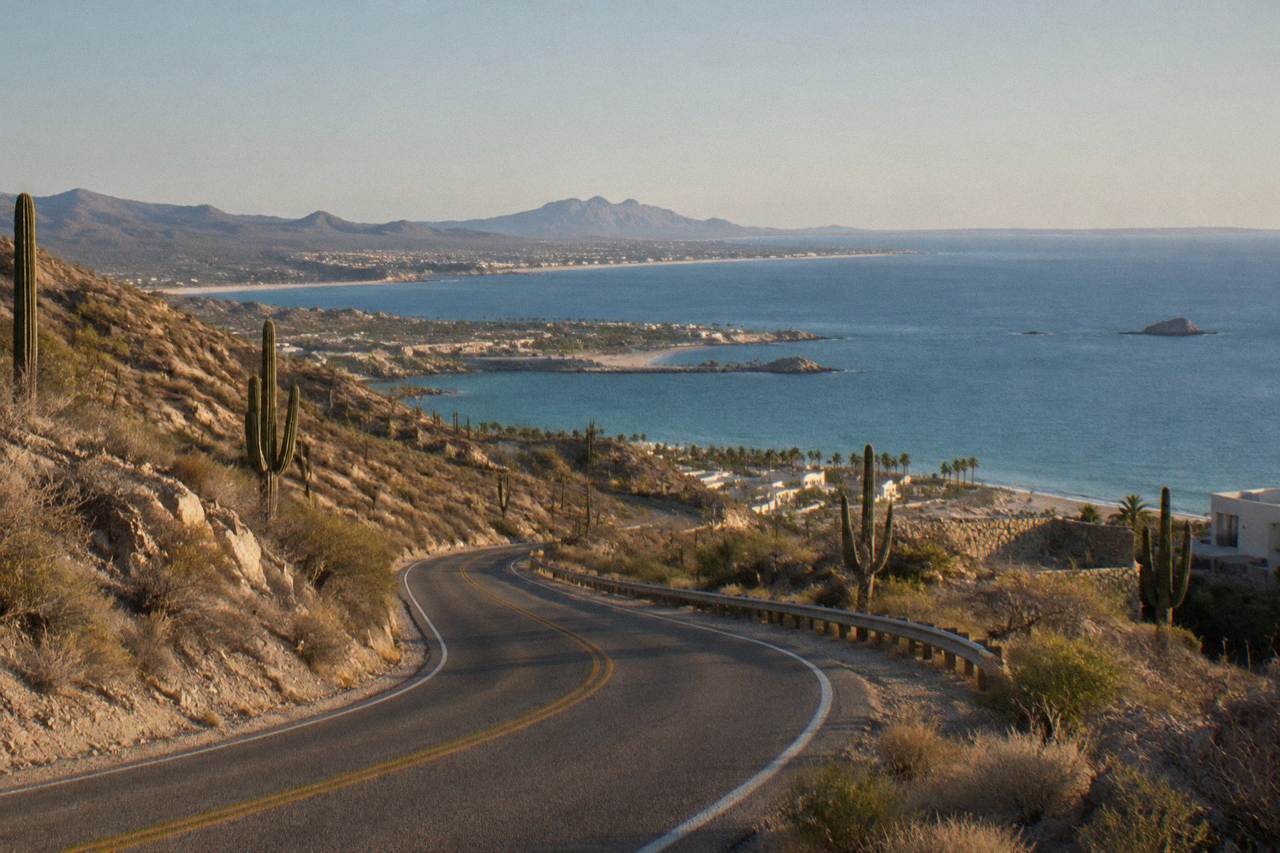 Coastal highway curving along desert hills toward the calm water of the Sea of Cortez near La Paz