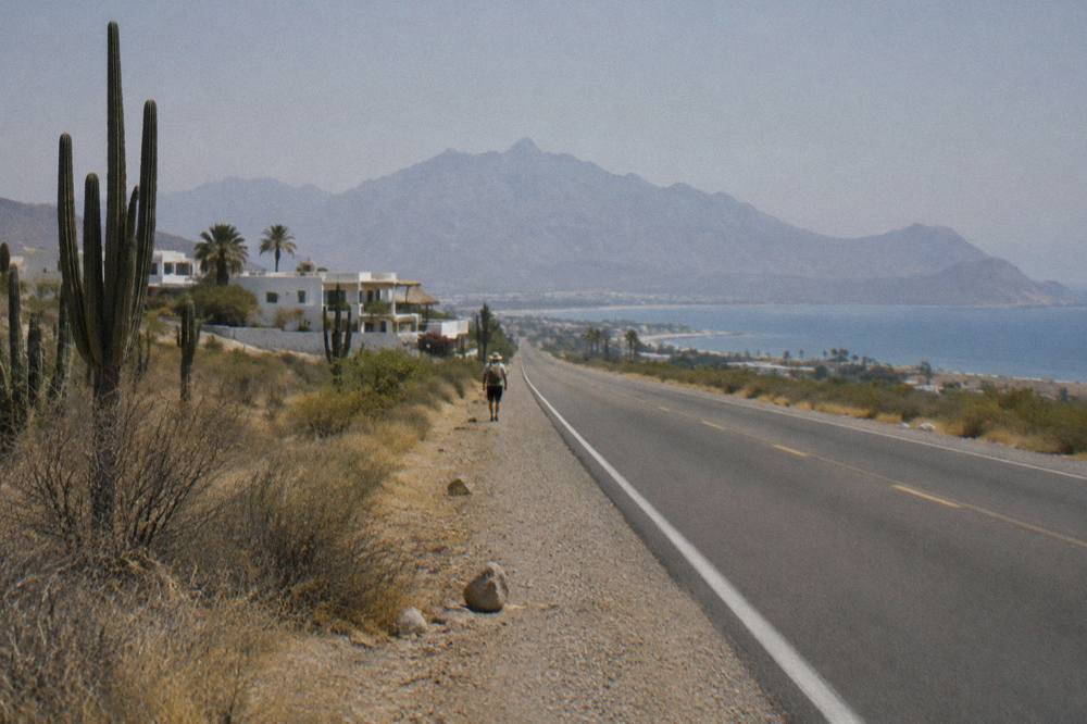Empty desert highway curving toward low mountains on the Baja peninsula