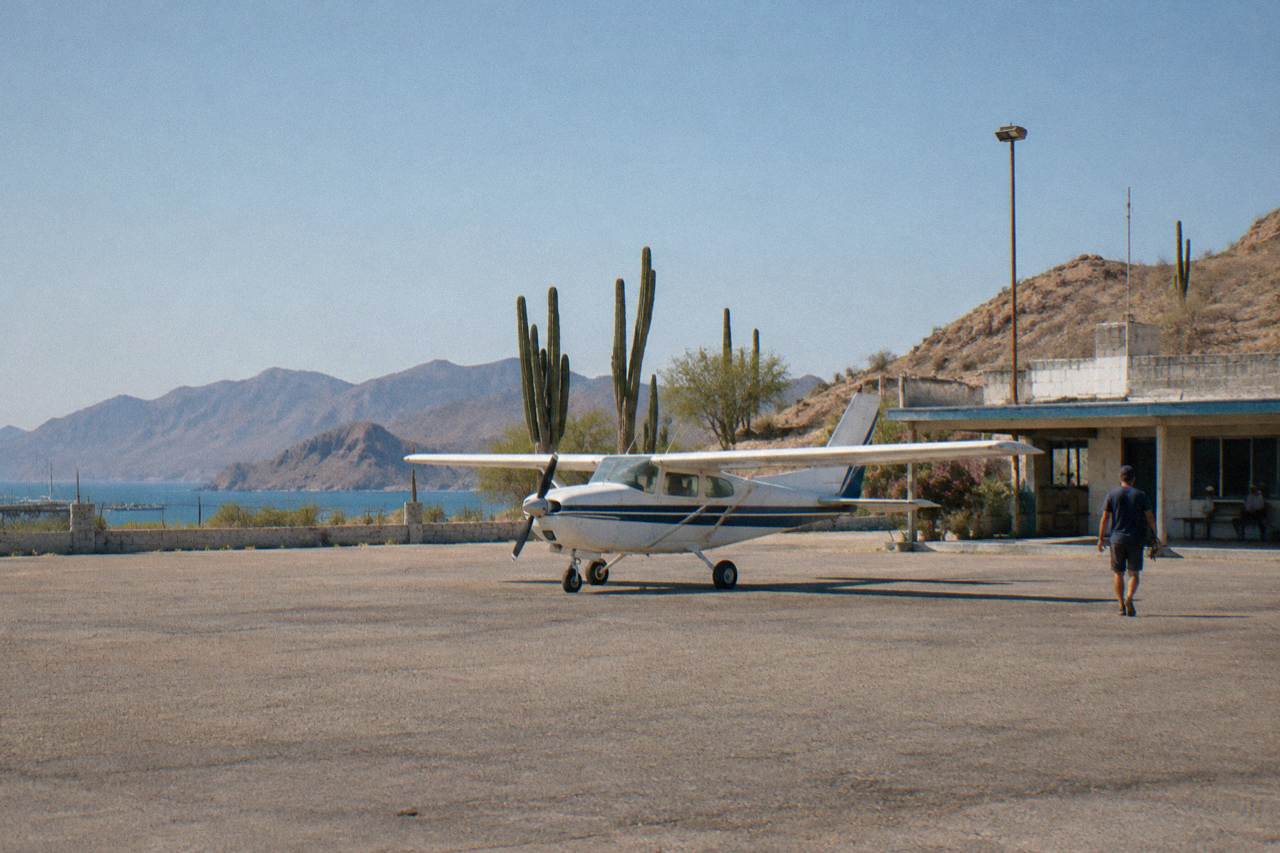 Small aircraft on a desert airstrip near the coast at La Paz with low hills in the distance