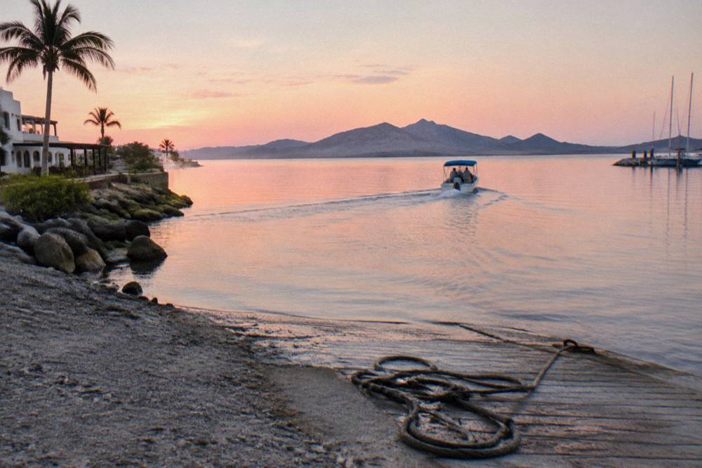 Small tour boat crossing flat morning water toward La Paz Bay