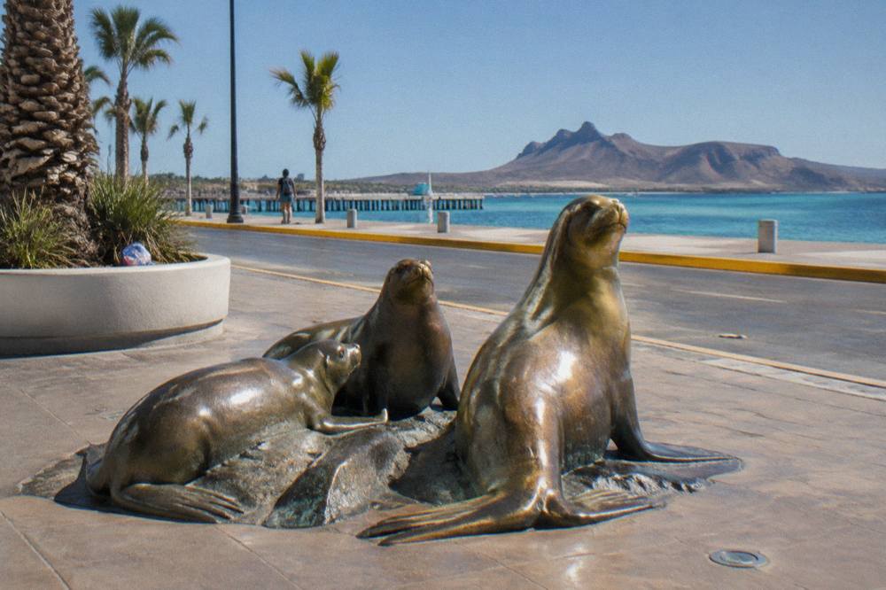 Sculpture-lined waterfront promenade in La Paz under a clear morning sky