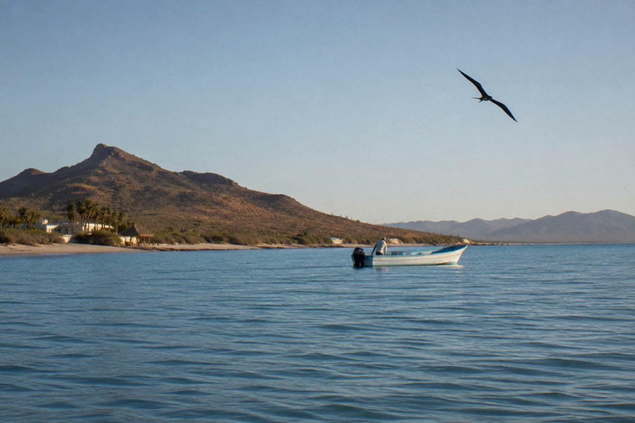 Calm blue water of a bay with a small boat holding position at a distance