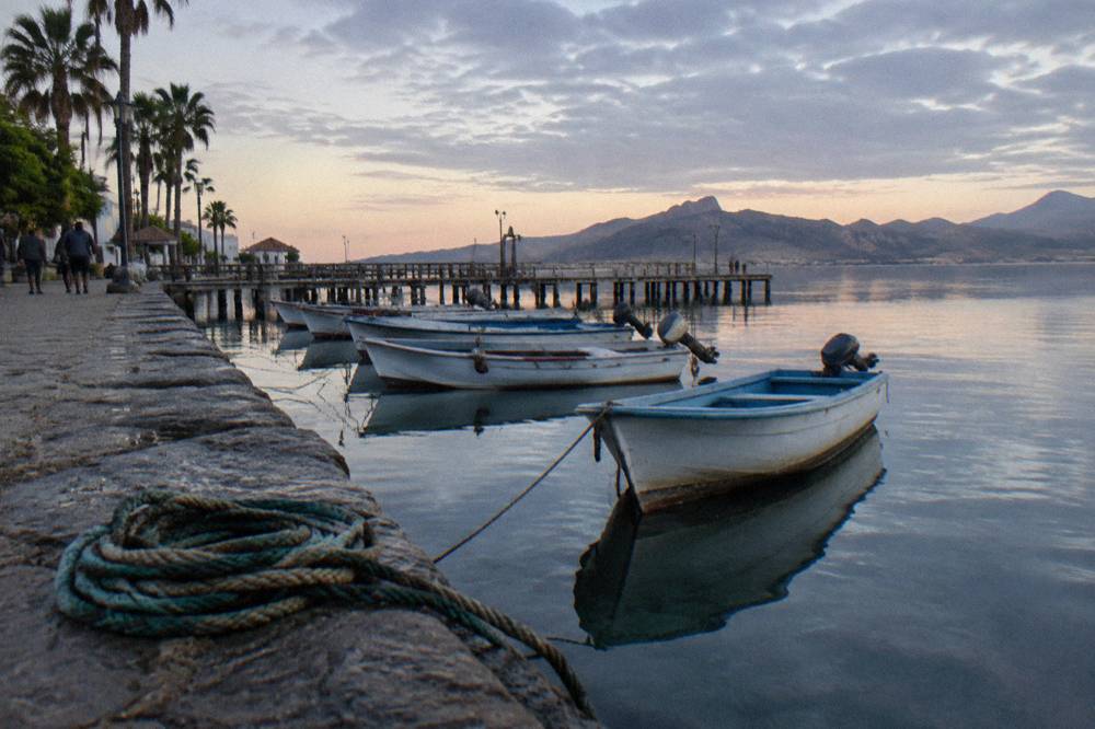 Boats moored along the La Paz Malecon at first light with the pier ahead