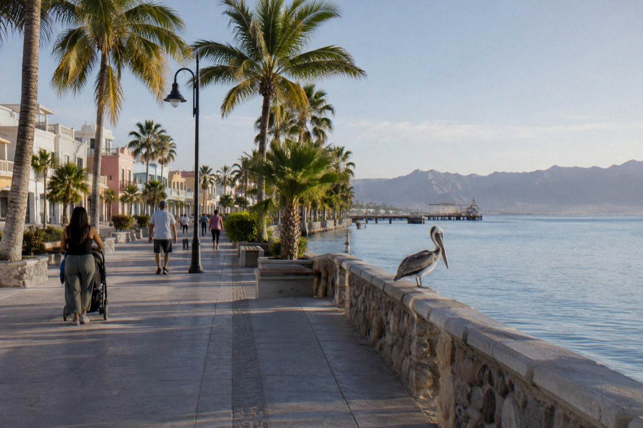 Quiet hotel street in La Paz with the Malecon boardwalk and calm bay beyond